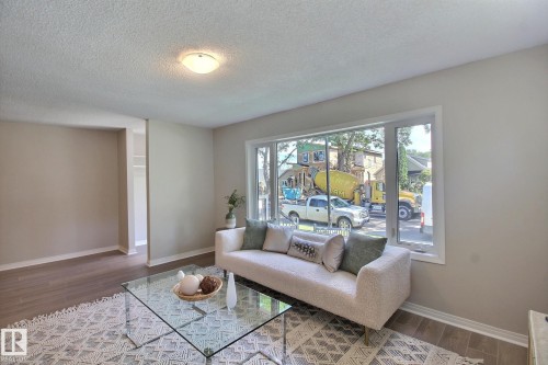 Living area featuring dark wood-style floors and a textured ceiling - 11512 67 Street, Edmonton, AB - Indoor Photo Showing Living Room