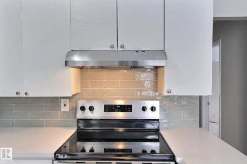 Kitchen with stainless steel range with electric cooktop and tasteful backsplash - 11512 67 Street, Edmonton, AB - Indoor Photo Showing Kitchen