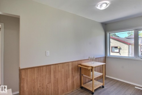 Unfurnished room with vinyl plank finished floors and a wainscoted wall - 11512 67 Street, Edmonton, AB - Indoor Photo Showing Other Room