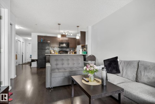 Living room featuring a textured ceiling and dark wood finished floors - 209 3353 16A, Edmonton, AB - Indoor Photo Showing Living Room