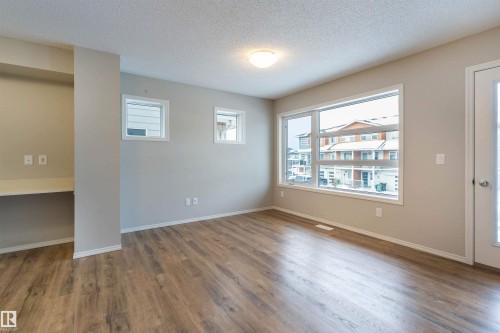 Spare room featuring a textured ceiling and wood finished floors - 17259 9A Avenue Sw, Edmonton, AB - Indoor Photo Showing Other Room