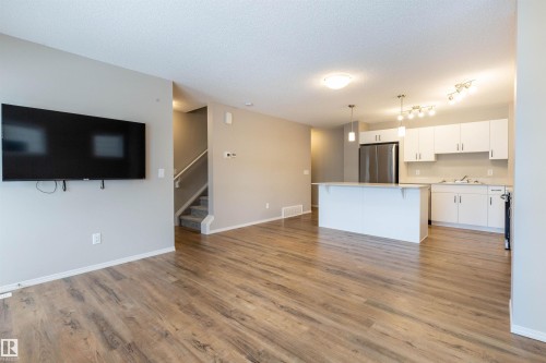 Unfurnished living room with light wood-style floors and a textured ceiling - 17259 9A Avenue Sw, Edmonton, AB - Indoor Photo Showing Kitchen