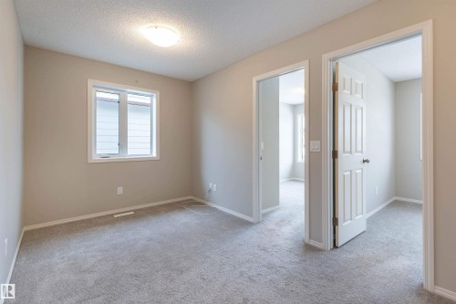 Unfurnished room featuring light carpet and a textured ceiling - 17259 9A Avenue Sw, Edmonton, AB - Indoor Photo Showing Other Room
