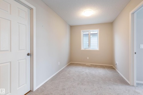 Spare room with a textured ceiling and light colored carpet - 17259 9A Avenue Sw, Edmonton, AB - Indoor Photo Showing Other Room