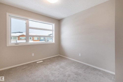 Unfurnished room with light carpet and a textured ceiling - 17259 9A Avenue Sw, Edmonton, AB - Indoor Photo Showing Other Room