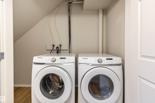 Laundry area with independent washer and dryer, vaulted ceiling, and wood finished floors - 17259 9A Avenue Sw, Edmonton, AB - Indoor Photo Showing Laundry Room