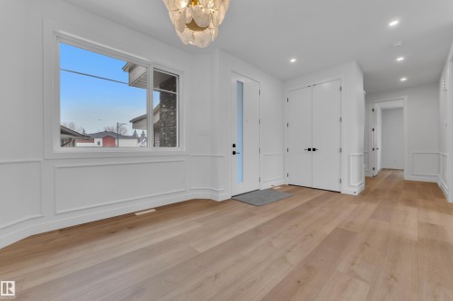 Foyer entrance with a chandelier, light wood-style flooring, and a decorative wall - 159 Graybriar Dr, Stony Plain, AB - Indoor Photo Showing Other Room