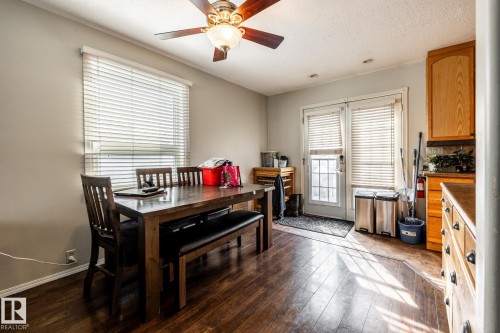 Dining room with dark wood-style flooring, a textured ceiling, and a ceiling fan - 69 Amherst Crescent, St. Albert, AB - Indoor Photo Showing Dining Room