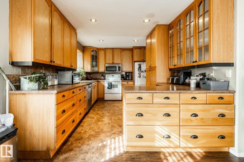 Kitchen featuring glass fronted cabinets, stainless steel appliances, recessed lighting, and tasteful backsplash - 69 Amherst Crescent, St. Albert, AB - Indoor Photo Showing Kitchen