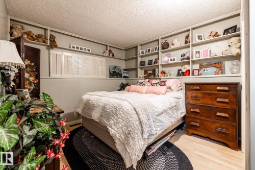 Bedroom with a textured ceiling and light wood finished floors - 69 Amherst Crescent, St. Albert, AB - Indoor Photo Showing Bedroom