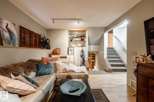 Living room with a textured ceiling, track lighting, and wood finished floors - 69 Amherst Crescent, St. Albert, AB - Indoor Photo Showing Living Room