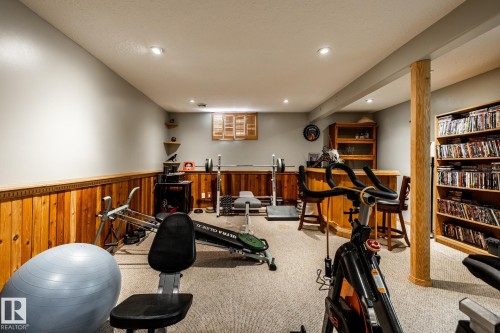Workout room featuring bar area, recessed lighting, wainscoting, wood walls, and light carpet - 69 Amherst Crescent, St. Albert, AB - Indoor