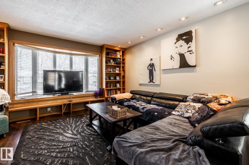 Living area featuring a textured ceiling, recessed lighting, and dark wood finished floors - 69 Amherst Crescent, St. Albert, AB - Indoor Photo Showing Living Room