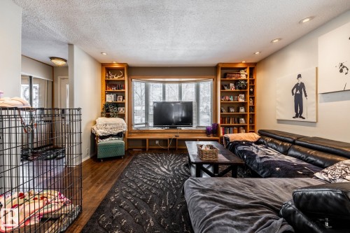 Living room with a textured ceiling, recessed lighting, dark wood finished floors, and built in shelves - 69 Amherst Crescent, St. Albert, AB - Indoor Photo Showing Other Room