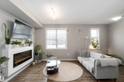 Living room featuring a glass covered fireplace, wood finished floors, a textured ceiling, and rail lighting - 