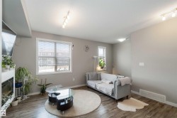 Living room featuring rail lighting, a textured ceiling, and hardwood / wood-style flooring - 