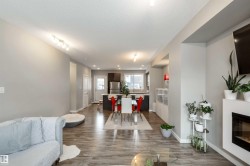 Living room with light wood-style floors, a textured ceiling, and a glass covered fireplace - 