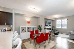 Dining room featuring dark wood-style floors, a textured ceiling, and track lighting - 