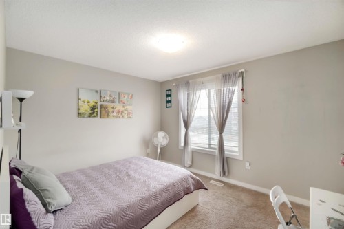 Carpeted bedroom with baseboards and a textured ceiling - 31 2803 James Mowatt Trail, Edmonton, AB - Indoor Photo Showing Bedroom