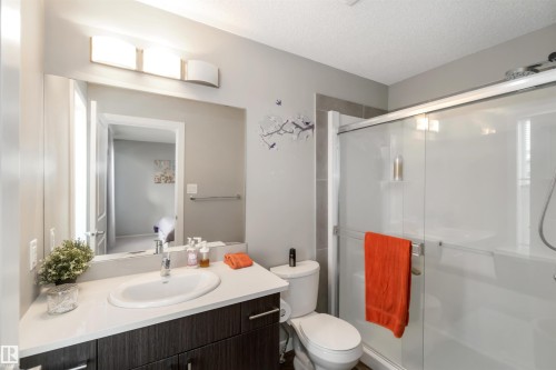Bathroom with a stall shower, vanity, a textured ceiling, and connected bathroom - 31 2803 James Mowatt Trail, Edmonton, AB - Indoor Photo Showing Bathroom