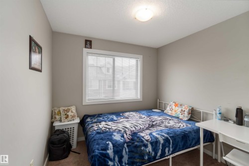 Bedroom with carpet floors and a textured ceiling - 31 2803 James Mowatt Trail, Edmonton, AB - Indoor Photo Showing Bedroom