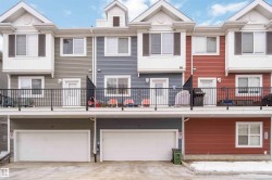 Back of property featuring an attached garage and a balcony - 