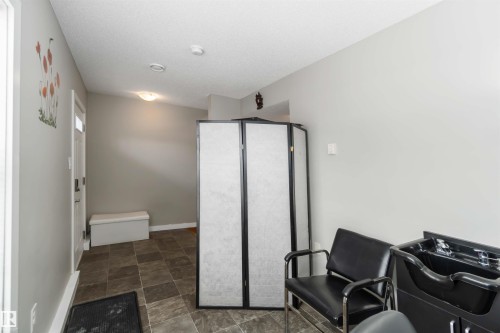Office space with stone finish floors and a textured ceiling - 31 2803 James Mowatt Trail, Edmonton, AB - Indoor