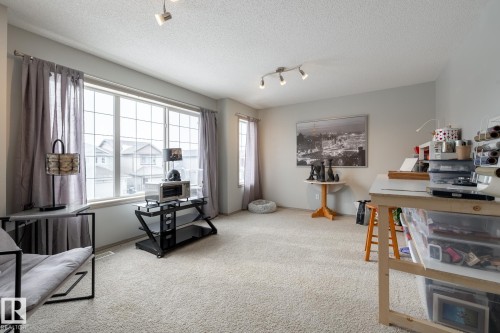 Sitting room with track lighting, light carpet, and a textured ceiling - 3312 17B Avenue, Edmonton, AB - Indoor