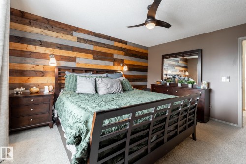Bedroom featuring wooden walls, light carpet, and ceiling fan - 3312 17B Avenue, Edmonton, AB - Indoor Photo Showing Bedroom