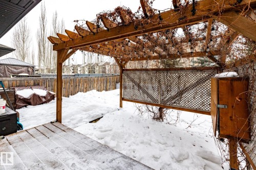 Snow covered patio featuring a pergola, a fenced backyard, and a deck - 3312 17B Avenue, Edmonton, AB - Outdoor With Deck Patio Veranda