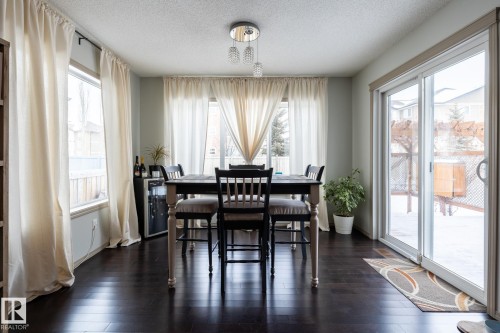Dining area featuring a textured ceiling, dark wood-type flooring, and plenty of natural light - 3312 17B Avenue, Edmonton, AB - Indoor Photo Showing Dining Room