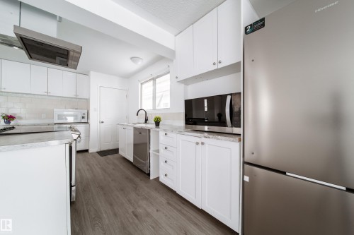 Kitchen featuring stainless steel appliances, extractor fan, white cabinets, and dark wood-style floors - 11430 81 Street, Edmonton, AB - Indoor Photo Showing Kitchen With Stainless Steel Kitchen