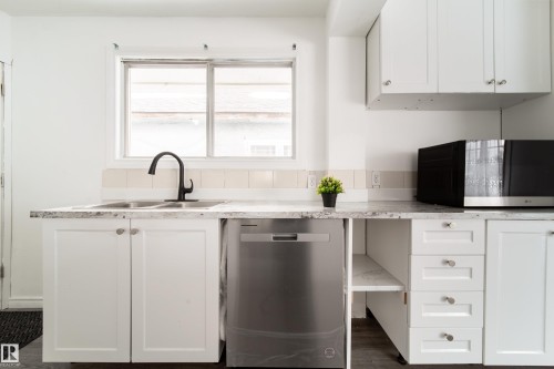 Kitchen with white cabinets, stainless steel appliances, and dark wood-style floors - 11430 81 Street, Edmonton, AB - Indoor Photo Showing Kitchen With Upgraded Kitchen