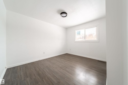 Empty room with dark wood finished floors and baseboards - 11430 81 Street, Edmonton, AB - Indoor Photo Showing Other Room