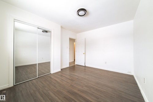 Unfurnished bedroom featuring a closet and dark wood-type flooring - 11430 81 Street, Edmonton, AB - Indoor Photo Showing Other Room