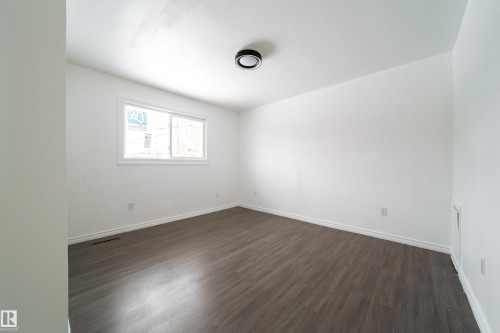 Unfurnished room featuring dark wood-type flooring and baseboards - 11430 81 Street, Edmonton, AB - Indoor Photo Showing Other Room
