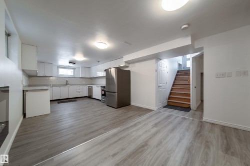 Kitchen featuring light countertops, white cabinets, stainless steel appliances, light wood-type flooring, and decorative backsplash - 11430 81 Street, Edmonton, AB - Indoor Photo Showing Kitchen