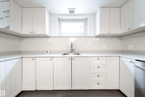 Kitchen with white cabinets, light countertops, tasteful backsplash, and dishwasher - 11430 81 Street, Edmonton, AB - Indoor Photo Showing Kitchen