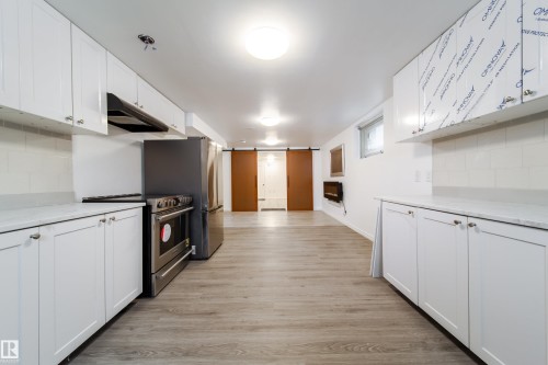 Kitchen featuring tasteful backsplash, white cabinetry, and stainless steel appliances - 11430 81 Street, Edmonton, AB - Indoor Photo Showing Kitchen