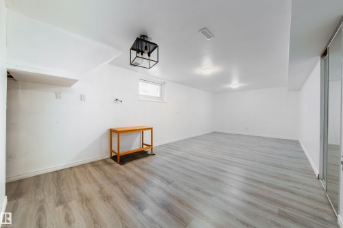 Below grade area featuring light wood-style floors and baseboards - 11430 81 Street, Edmonton, AB - Indoor Photo Showing Other Room