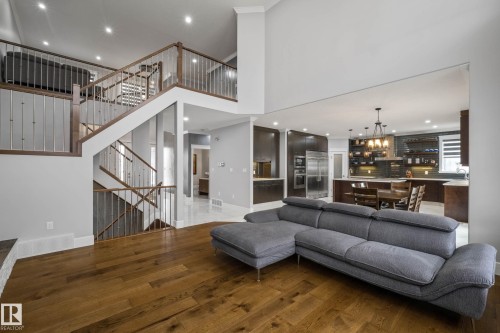 Living room with dark wood-style flooring, a high ceiling, and a chandelier - 4086 Whispering River Drive, Edmonton, AB - Indoor