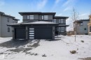Prairie-style home featuring stone siding, stucco siding, driveway, and a garage - 4086 Whispering River Drive, Edmonton, AB  - Outdoor With Facade 