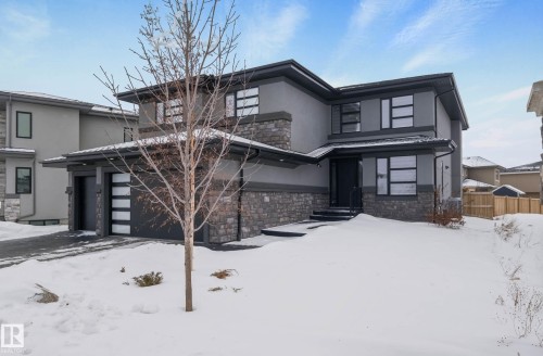 Prairie-style house featuring stone siding, stucco siding, and an attached garage - 4086 Whispering River Drive, Edmonton, AB - Outdoor With Facade