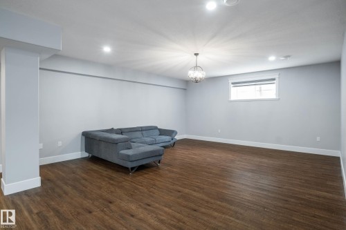 Unfurnished room with dark wood-style flooring and hanging lights - 4086 Whispering River Drive, Edmonton, AB - Indoor