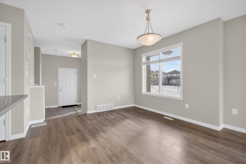 Unfurnished dining area with dark wood finished floors and a textured ceiling - 2704 Coughlan Green, Edmonton, AB - Indoor Photo Showing Other Room