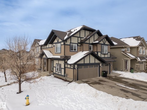 Tudor-style house with driveway, an attached garage, and roof with shingles - 2704 Coughlan Green, Edmonton, AB - Outdoor