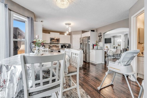 Dining room featuring arched walkways, dark wood finished floors, and a textured ceiling - 4404 150 Avenue, Edmonton, AB - Indoor Photo Showing Dining Room