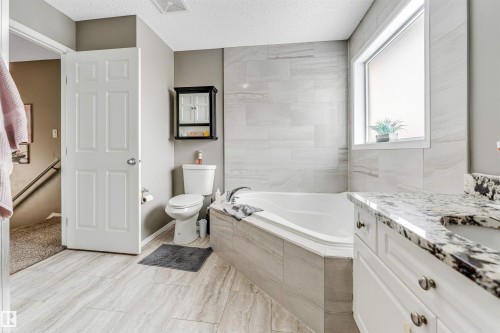 Bathroom with a bath, vanity, and a textured ceiling - 4404 150 Avenue, Edmonton, AB - Indoor Photo Showing Bathroom