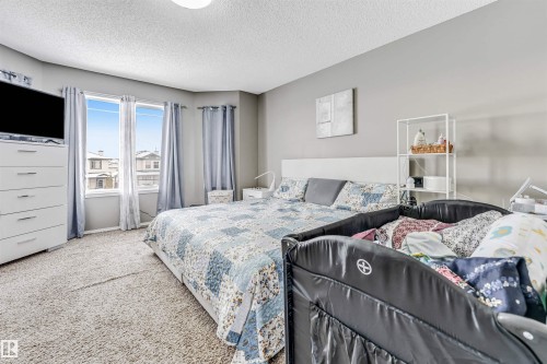 Bedroom with a textured ceiling and carpet floors - 4404 150 Avenue, Edmonton, AB - Indoor Photo Showing Bedroom
