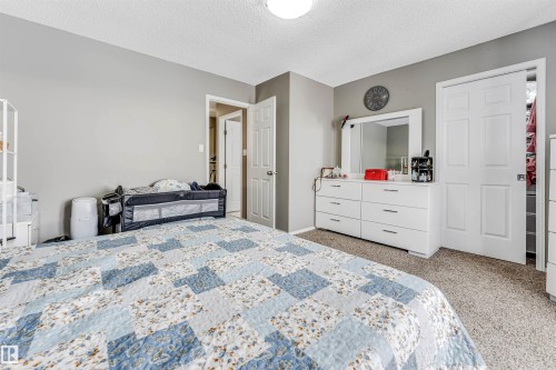 Bedroom featuring light carpet and a textured ceiling - 4404 150 Avenue, Edmonton, AB - Indoor Photo Showing Bedroom